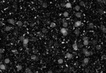 Close up of scattered white particles on a dark textured background resembling snowfall, cosmic dust, or abstract specks, creating a stock visual for designers and creatives