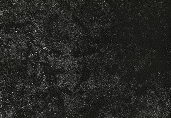 Close up of a deep black textured surface with subtle grain and scattered light specks, offering a versatile backdrop for design, photography, and digital art projects