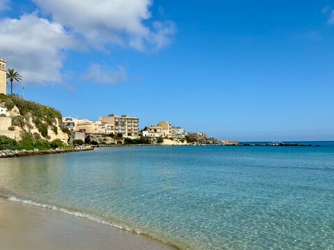 Sandy beach with turquoise water and townscape in late autumn, Otranto, Province of Lecce, Puglia, Italy