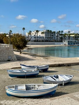 Boats on a sandy beach in fronft of coastal townscape in late autumn, Otranto, Province of Lecce, Puglia, Italy