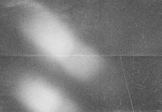 Abstract black and white noise texture featuring soft diagonal light streak and film grain, ideal as a versatile background, overlay, or design element in creative projects