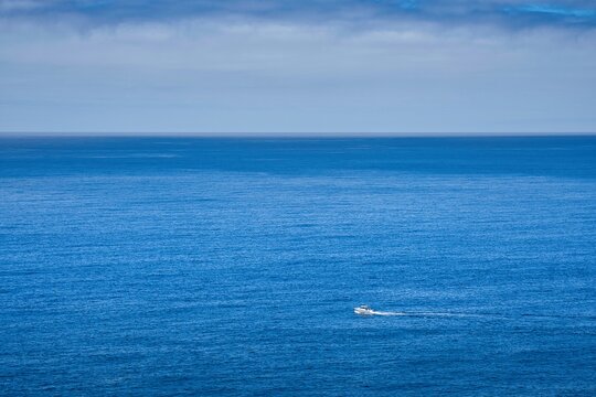 A boat is sailing in the ocean with a clear blue sky in the background