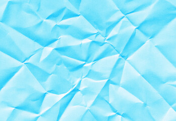 Obraz premium Blue crumpled paper background with soft folds, subtle shadows, and textured creases for versatile design use in presentations, banners, posters, web graphics, and branding layouts