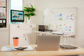 Businesswoman smiling while using laptop and talking on mobile phone at desk in office and at home or coffee shop.