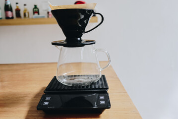 Coffee brewing setup on a digital scale, clear glass carafe.