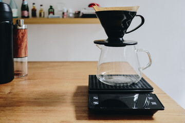 Coffee Brewing Setup with Dripper, Carafe, and Scale on Wooden Countertop.