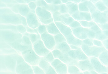 Crystal clear turquoise pool water with sunlit ripples and shimmering reflections creating an abstract, refreshing surface ideal for relaxation, summer, and travel visuals