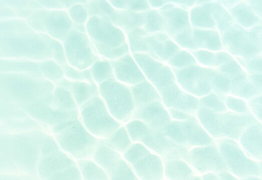 Crystal clear turquoise pool water with sunlit ripples and shimmering reflections creating an abstract, refreshing surface ideal for relaxation, summer, and travel visuals