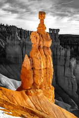 Hoodoo rock needle called „Thors hammer“ in Bryce Canyon National Park (Utah, USA) on a sunny winter morning. Contrasting colorful sandstone formation isolated on black and white grayscale background.