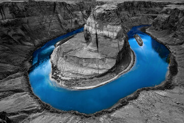 Horseshoe Bend is a big meander of Colorado River near Page, Arizona, USA, part of Grand Canyon. Panoramic view of river loop. Colorful blue water isolated on black and white grayscale background.
