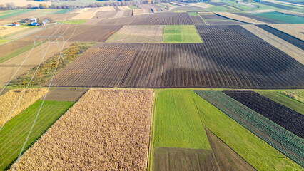 Aerial view of vast agricultural fields showcasing various crops. The landscape features rich textures and colors, highlighting the agrarian lifestyle and farming practices.