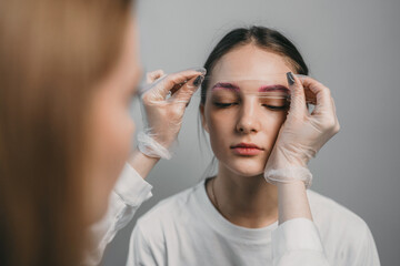 eyebrow shaping session, precision eyebrow sculpting involving model and professional aesthetician