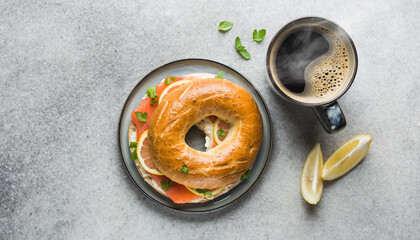 Delicious smoked salmon bagel with fresh lemon slices and a steaming cup of coffee