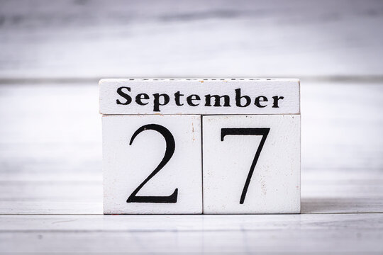 A wooden calendar displaying the date September 27, symbolizing the passage of time or upcoming events. Ideal for concepts of schedules, planning, or seasonal changes.