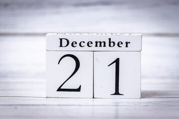 The date displayed is December 21 on a classic wooden calendar block. This signifies the start of winter and holiday season, perfect for seasonal marketing.