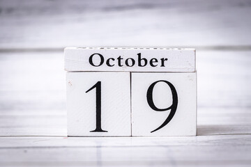 Wooden calendar showing the date October 19, emphasizing the changing seasons and time management. Ideal for events, planning, and seasonal themes.