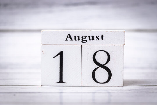 A white wooden calendar displaying the date August 18. Ideal for organizing schedules, planning events, or symbolizing a specific day in August for various purposes.