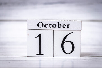 Display of a wooden calendar showing the date as October 16. The simple design emphasizes the significance of date marking for events, reminders, and planning.