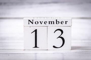 Calendar blocks displaying the date November 13 against a light wooden background, perfect for autumn-themed designs, marketing, or planning.