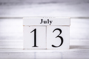 Wooden calendar blocks display the date July 13. This simple yet elegant decoration can symbolize celebrations or reminders in home, office, or event settings.