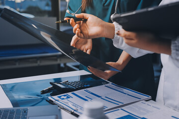 Group of doctors attending seminar in hospital lecture hall with senior physician giving medical presentation and professional training session on healthcare practices