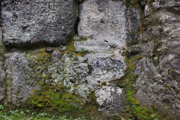 Ancient stone wall with moss and weathered texture