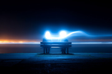 Couple Silhouetted on A Bench at Night with Swirling Light Trails Effect