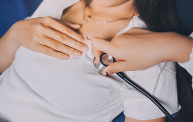 Doctor examining patient with stethoscope in hospital bed. Medical care and healthcare concept in a clinical setting.