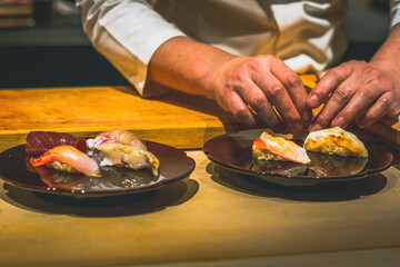 hands of japanese omakase chef preparing sushi at omakase counter