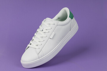 White sneaker on purple background. Stylish and modern footwear for casual fashion, sportswear, and streetwear trends.