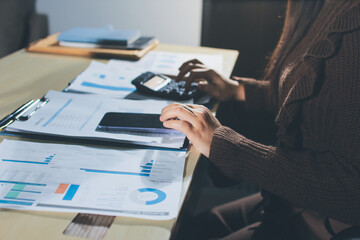 Close-up of businessman's hands making notes, mobiles, chart, desk, office