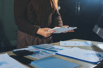 Close-up of businessman's hands making notes, mobiles, chart, desk, office