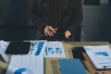 Close-up of businessman's hands making notes, mobiles, chart, desk, office
