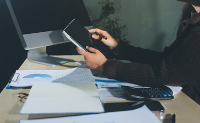 Close-up of businessman's hands making notes, mobiles, chart, desk, office