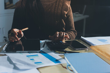 Close-up of businessman's hands making notes, mobiles, chart, desk, office