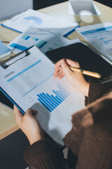 Close-up of businessman's hands making notes, mobiles, chart, desk, office
