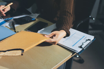 Close-up of businessman's hands making notes, mobiles, chart, desk, office