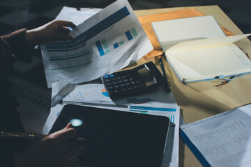 Close-up of businessman's hands making notes, mobiles, chart, desk, office