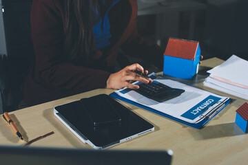 Customer signing a real estate contract in real estate agency.