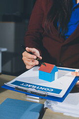 Customer signing a real estate contract in real estate agency.