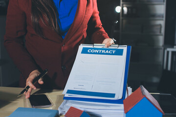 Customer signing a real estate contract in real estate agency.