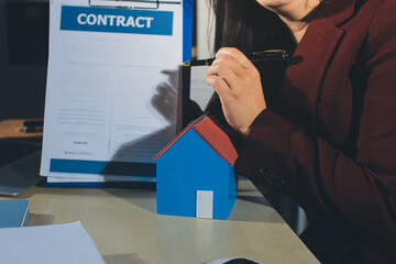 Customer signing a real estate contract in real estate agency.