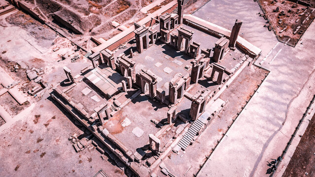 Aerial view of the stark, ancient ruins of Persepolis stand in muted tones, a silent testament to history, Fars Province, Iran.