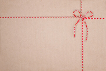 Red and White Christmas String Tied in Bow on Kraft Paper Background