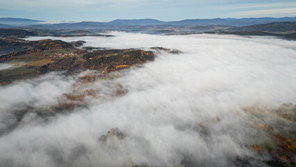 Evening sky glows above the Bavarian Forest and Straubing Bogen valleys where fog and sunlight create a warm autumn sunset scene in Bavaria Germany