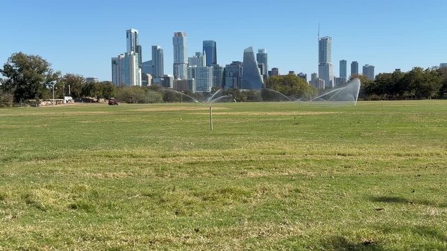 Low angle of Austin Texas Skyline watering grass
