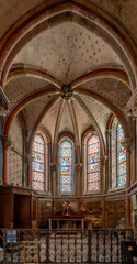 Fototapeta premium Semur-En-Auxois, France - 10 21 2025: Collegiate Church of Notre-Dame. Detail view of the Saint-Joseph chapel with painted decorations and stained glass windows restored by Viollet-Le-Duc