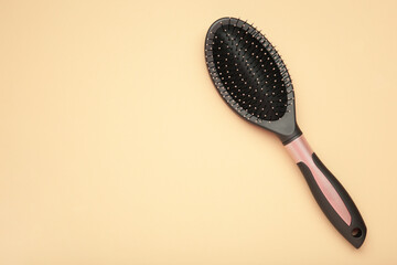Massage hairbrush on beige background.