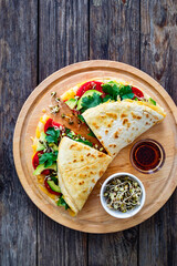 Healthy breakfast - italian piada wraps with scrambled eggs, tomatoes, avocado, coriander and bean sprouts. Top view