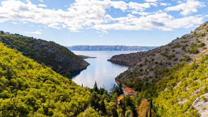 Naklejka premium Cinematic Aerial View of Croatian Landscape – Blue Adriatic Bay Surrounded by Wild Forests and Untouched Mediterranean Nature